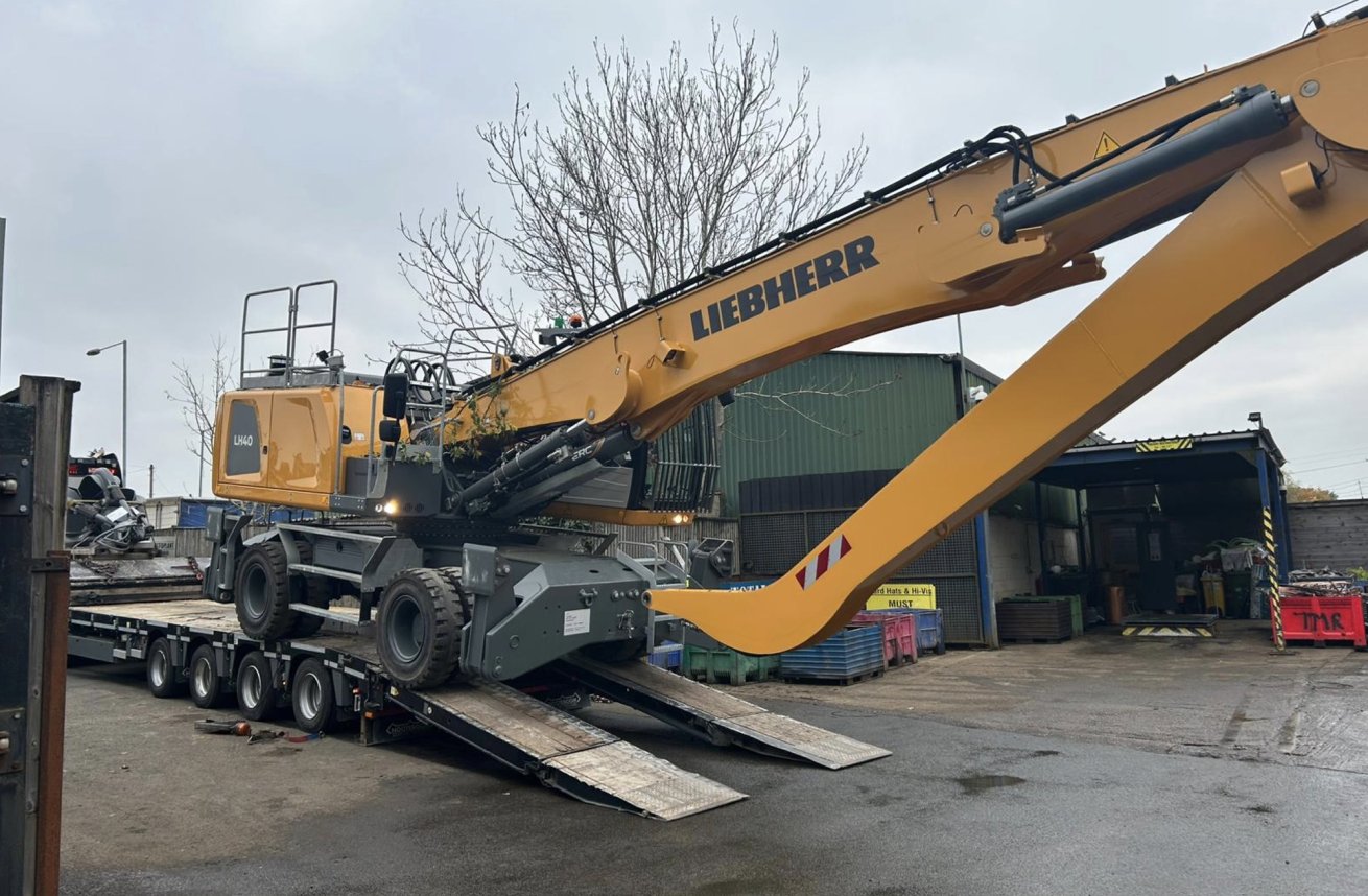 LH 40 Scrap handler being unloaded from a flatbed truck.